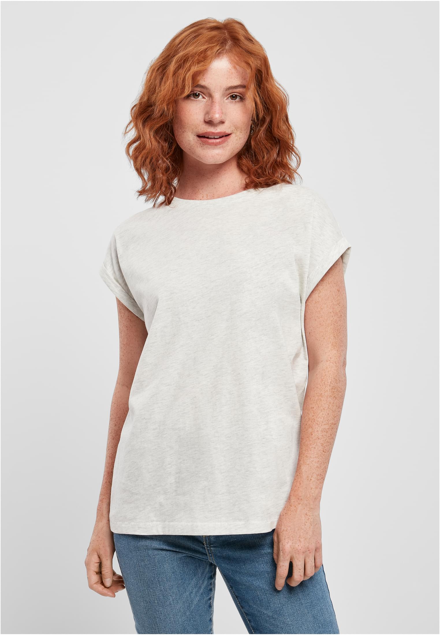 En kvinna med rött hår bär en ljusgråmelerad Ladies Extended Shoulder Tee.