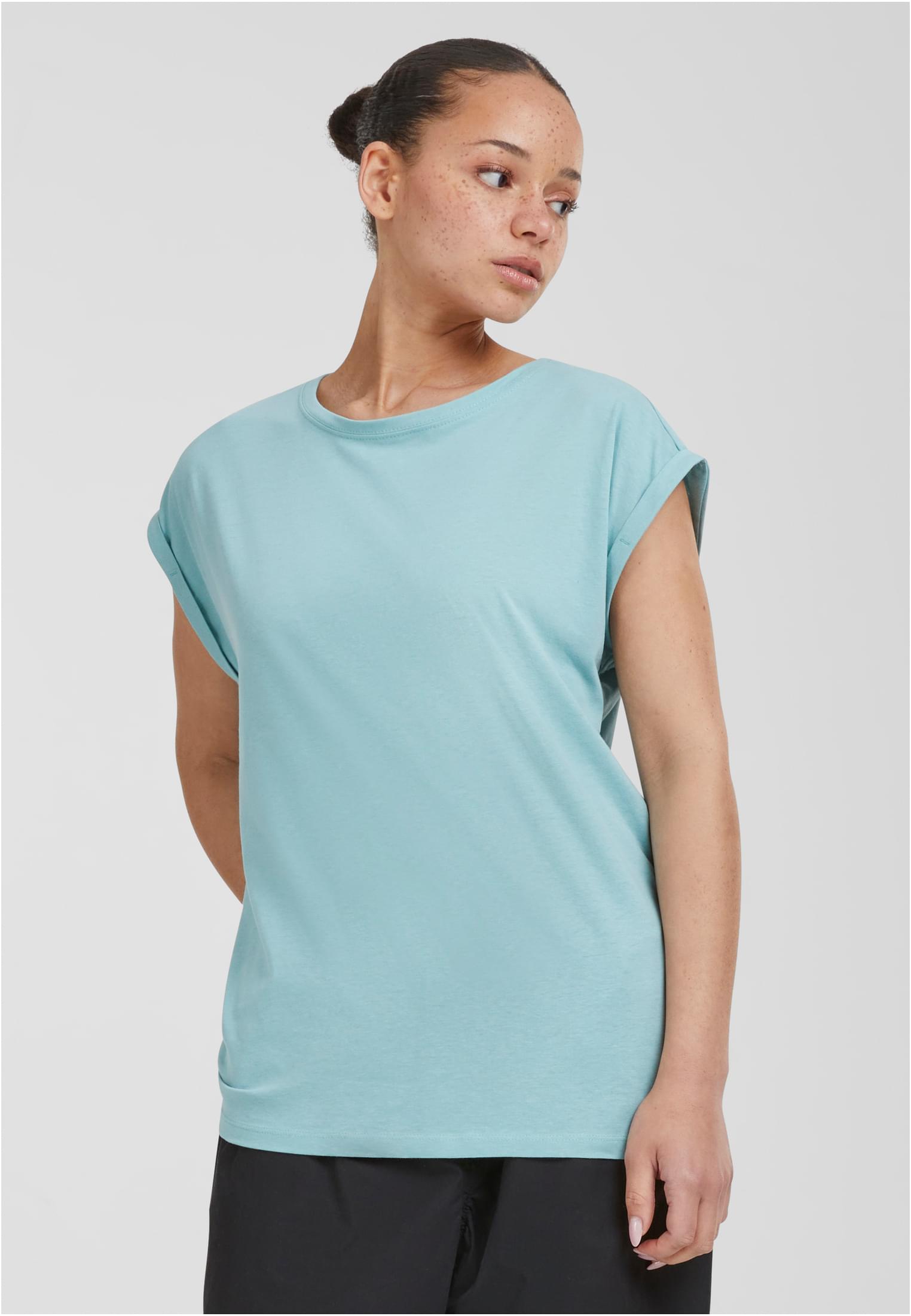 En kvinna som bär en mintgrön Ladies Extended Shoulder Tee från Urban Classics mot en ljusgrå bakgrund.