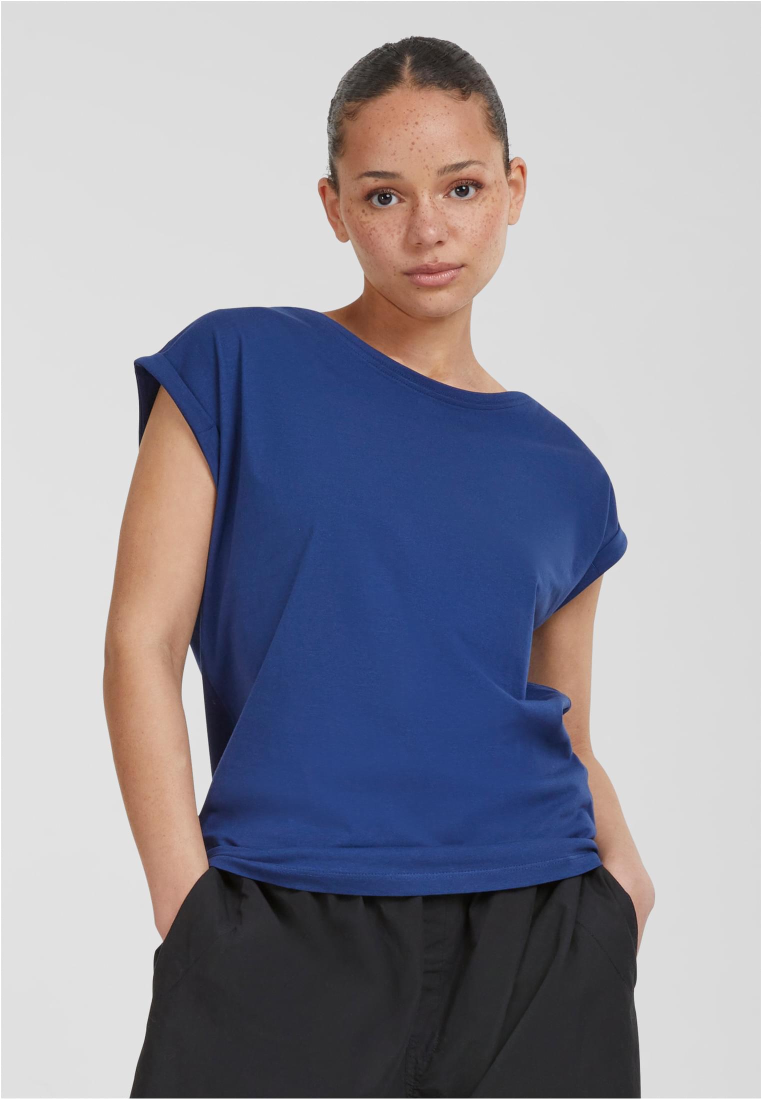 En kvinna som bär en blå Ladies Extended Shoulder Tee.
