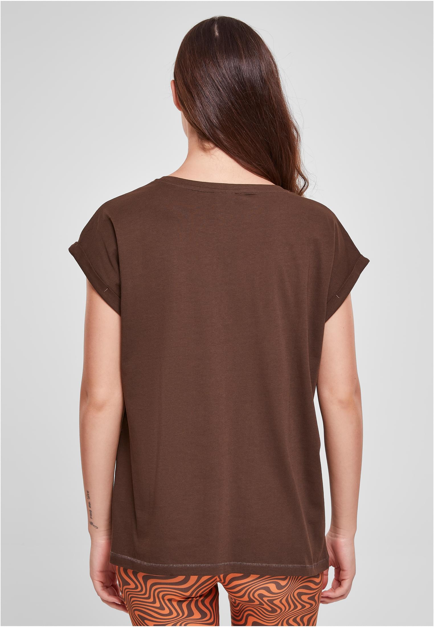 Baksidan av en kvinna som bär en brun Ladies Extended Shoulder Tee med uppkavlade ärmar.