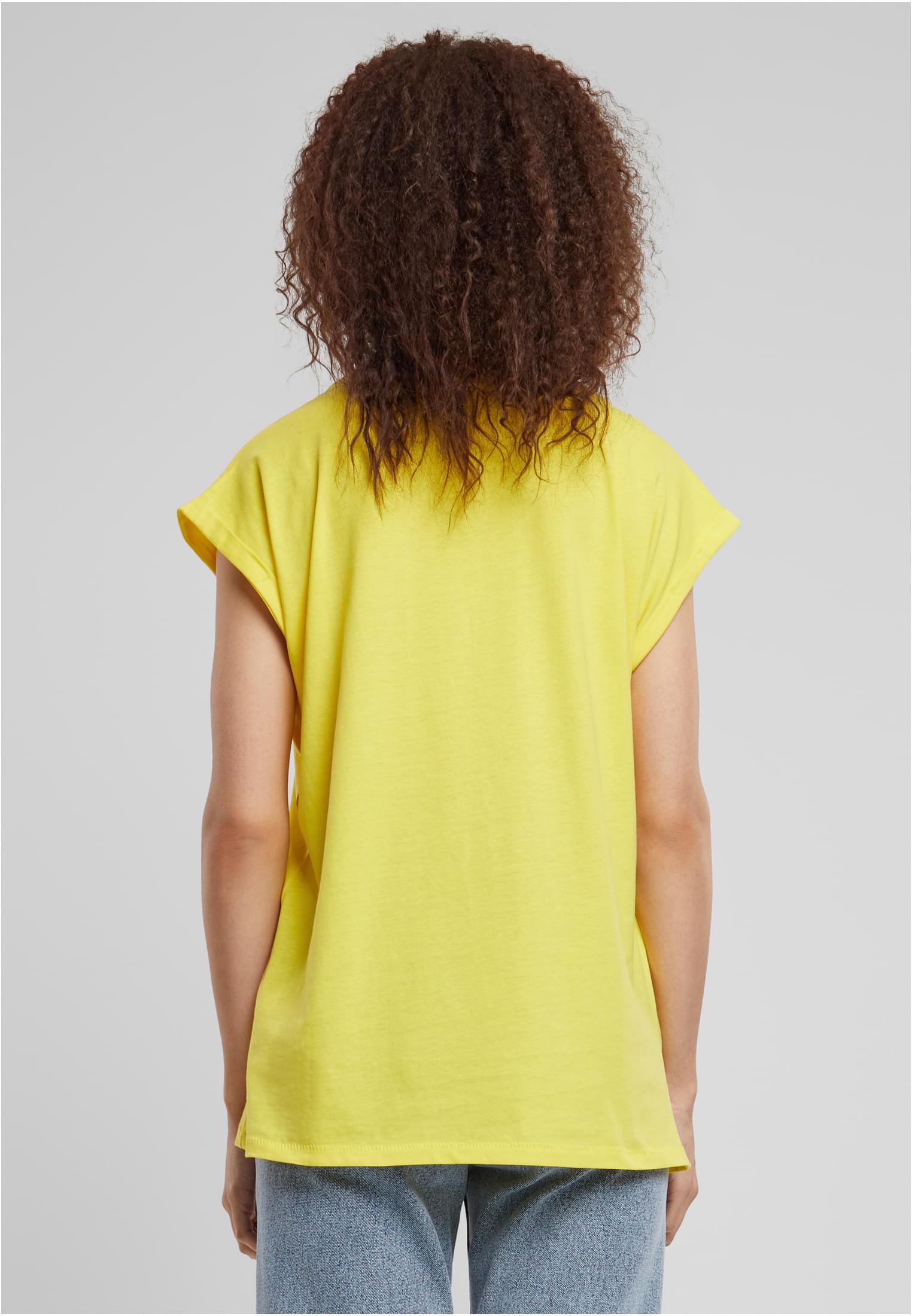 Kvinna sedd bakifrån som bär en gul Ladies Extended Shoulder Tee.