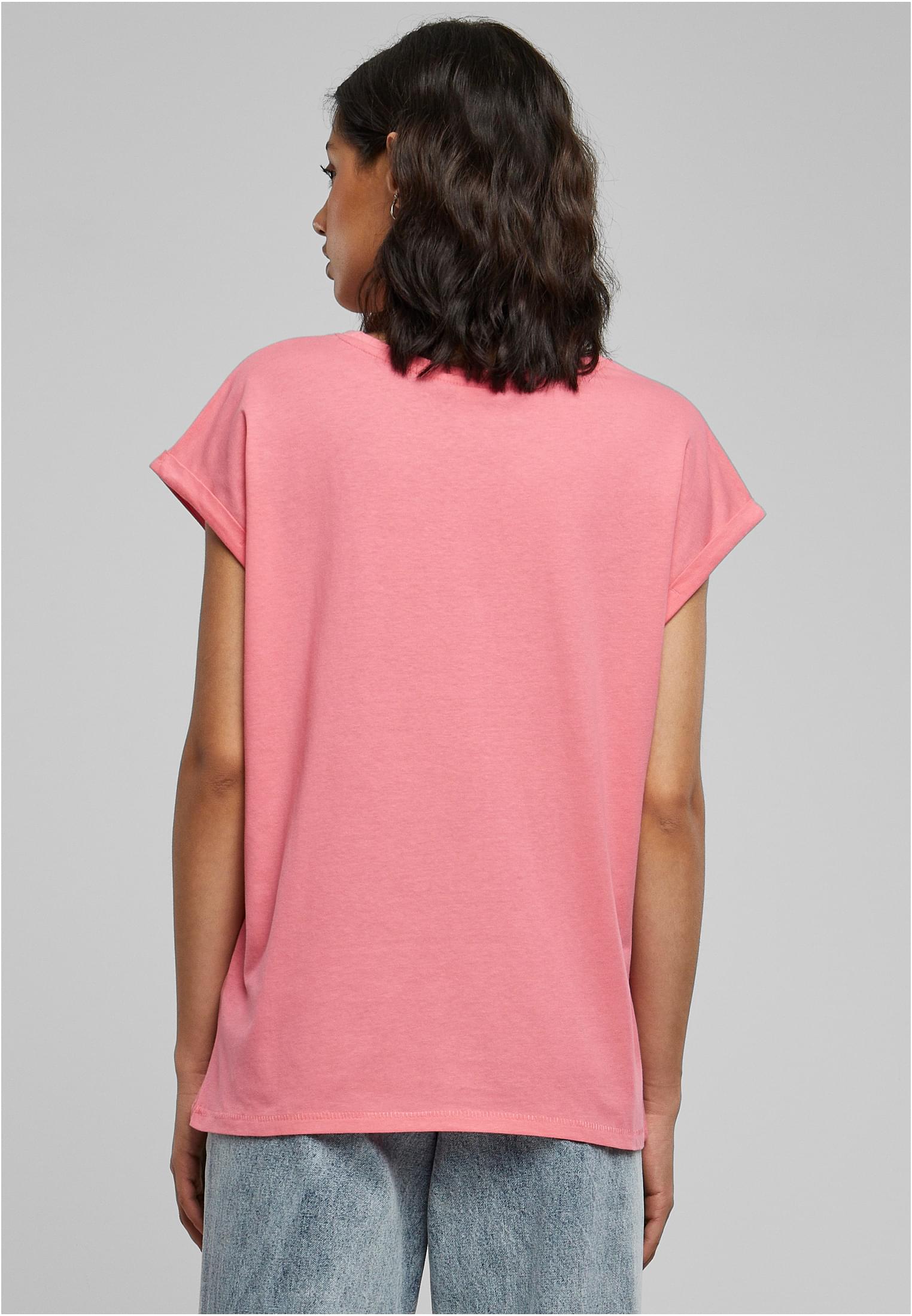 Kvinna sedd bakifrån i en rosa Ladies Extended Shoulder Tee med uppvikta ärmar.