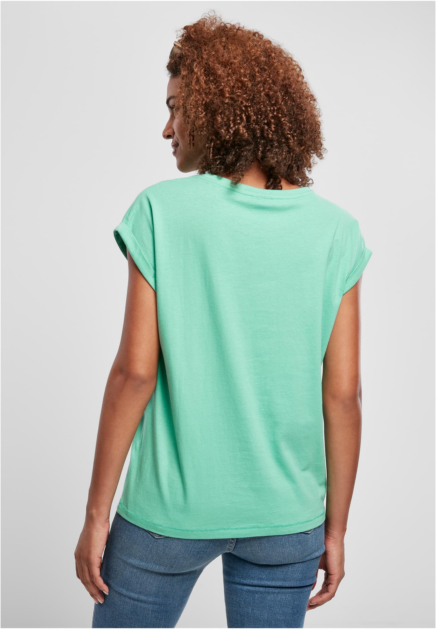 Kvinna sedd bakifrån som bär en mintgrön Ladies Extended Shoulder Tee.