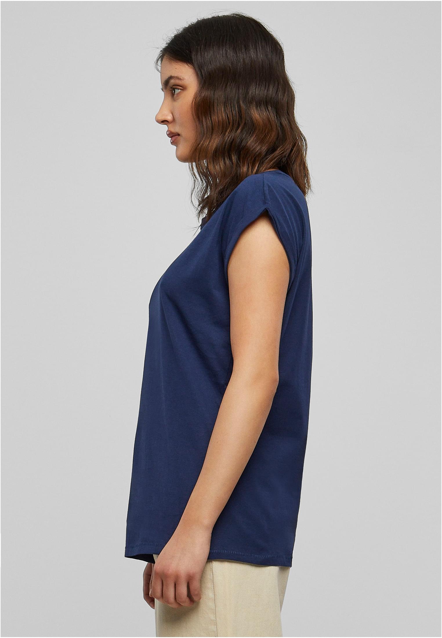 Sidoprofil av en kvinna som bär en mörkblå t-shirt med nedhasad axel.