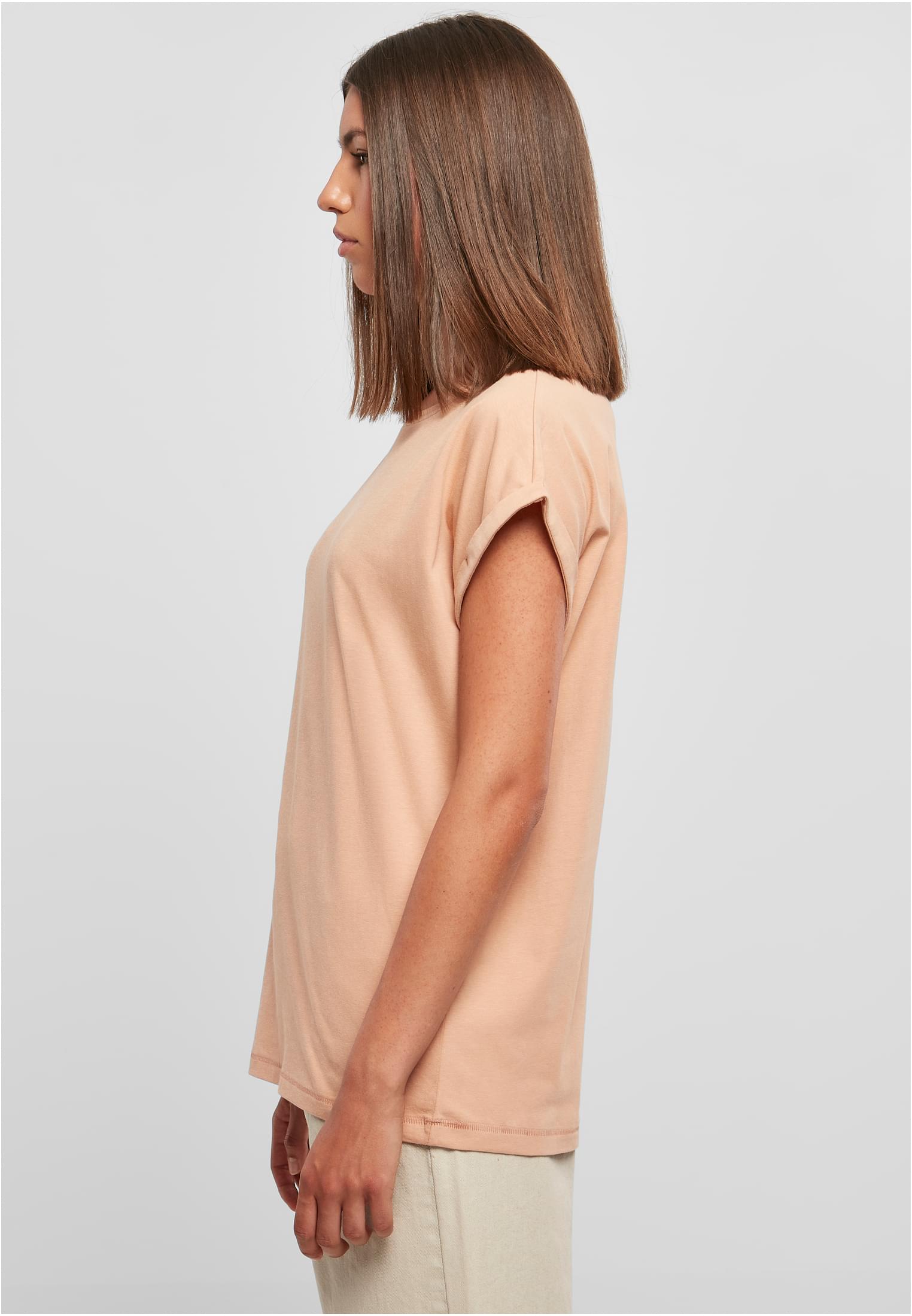Sidovy av en modell som bär t-shirten UC Ladies Extended Shoulder Tee i frostmint.