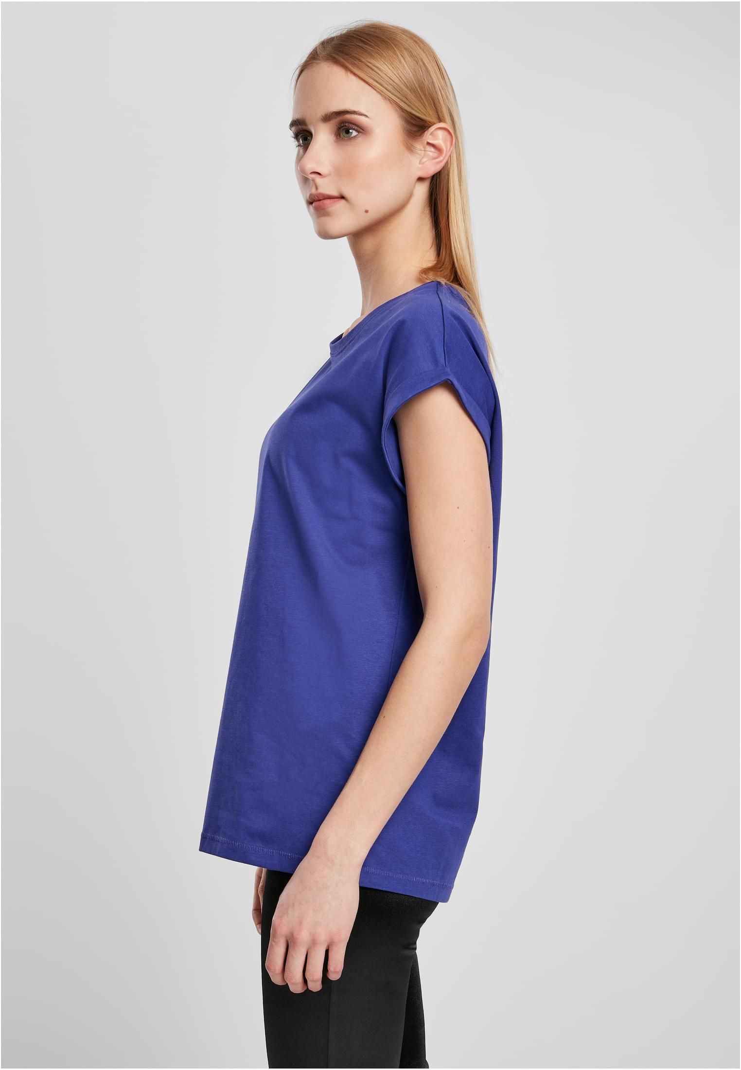 Sidovy av en kvinna som bär en blå Ladies Extended Shoulder Tee.
