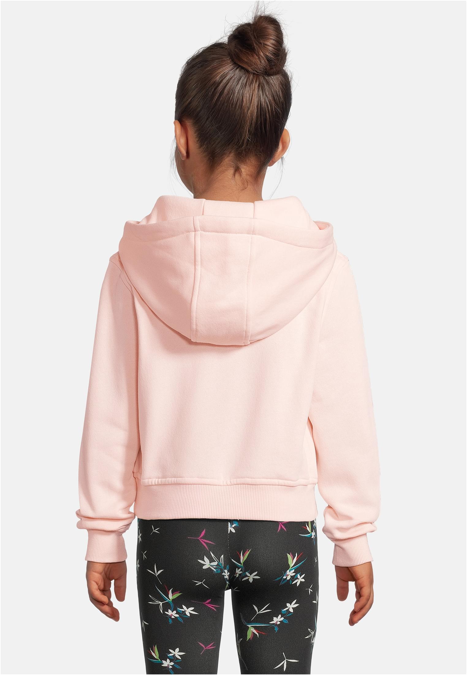 En ung flicka sedd bakifrån, iförd en ljusrosa Bow Hoody och mönstrade leggings.